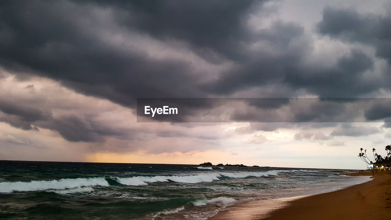 SCENIC VIEW OF BEACH DURING SUNSET