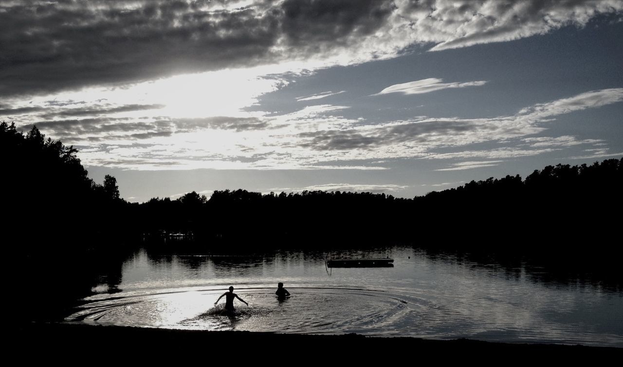Silhouette people enjoying in lake