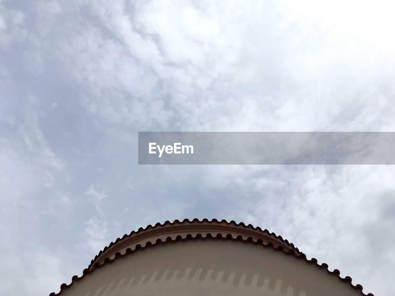 LOW ANGLE VIEW OF BUILDING AGAINST CLOUDS