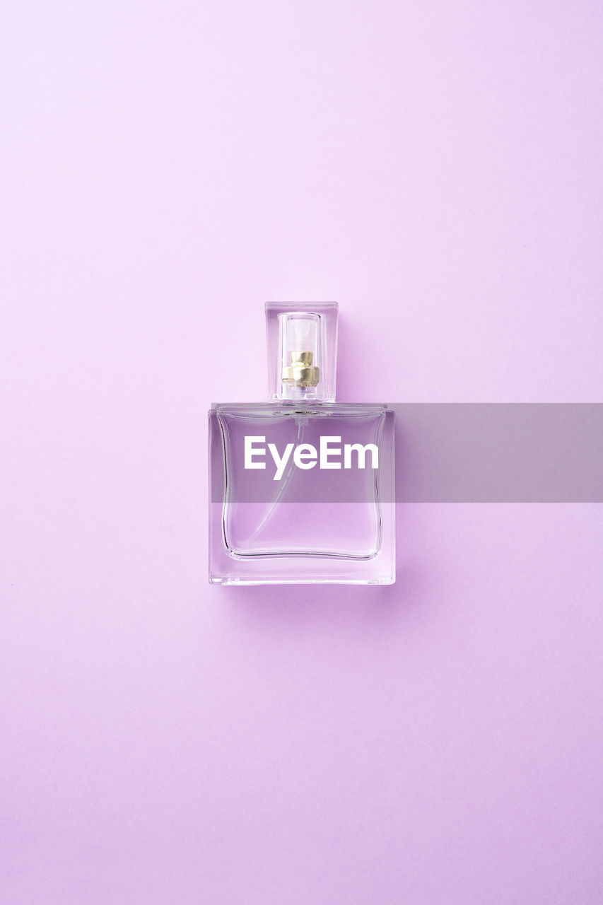 Close-up of perfume sprayer against purple background