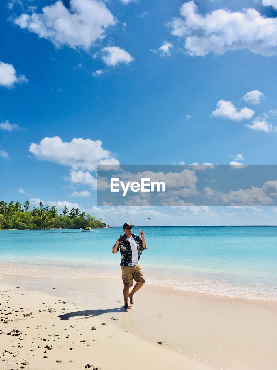 Full length of man standing on shore at beach against sky