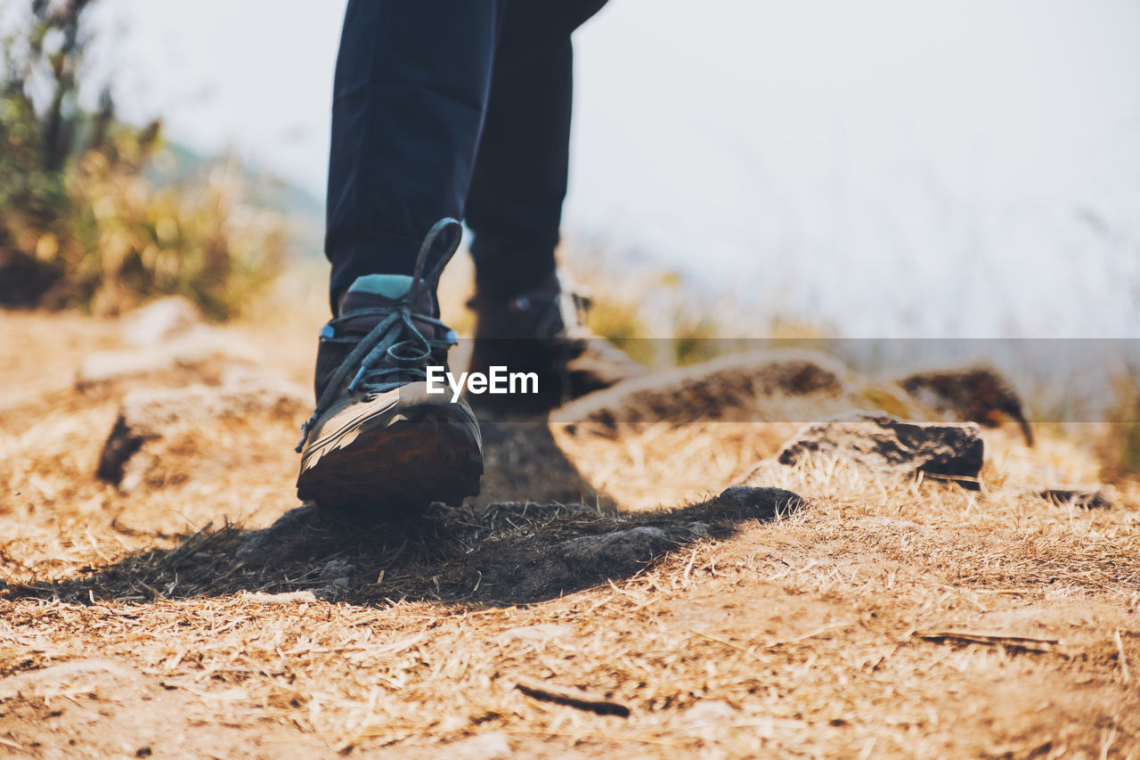 Low section of man standing on cliff