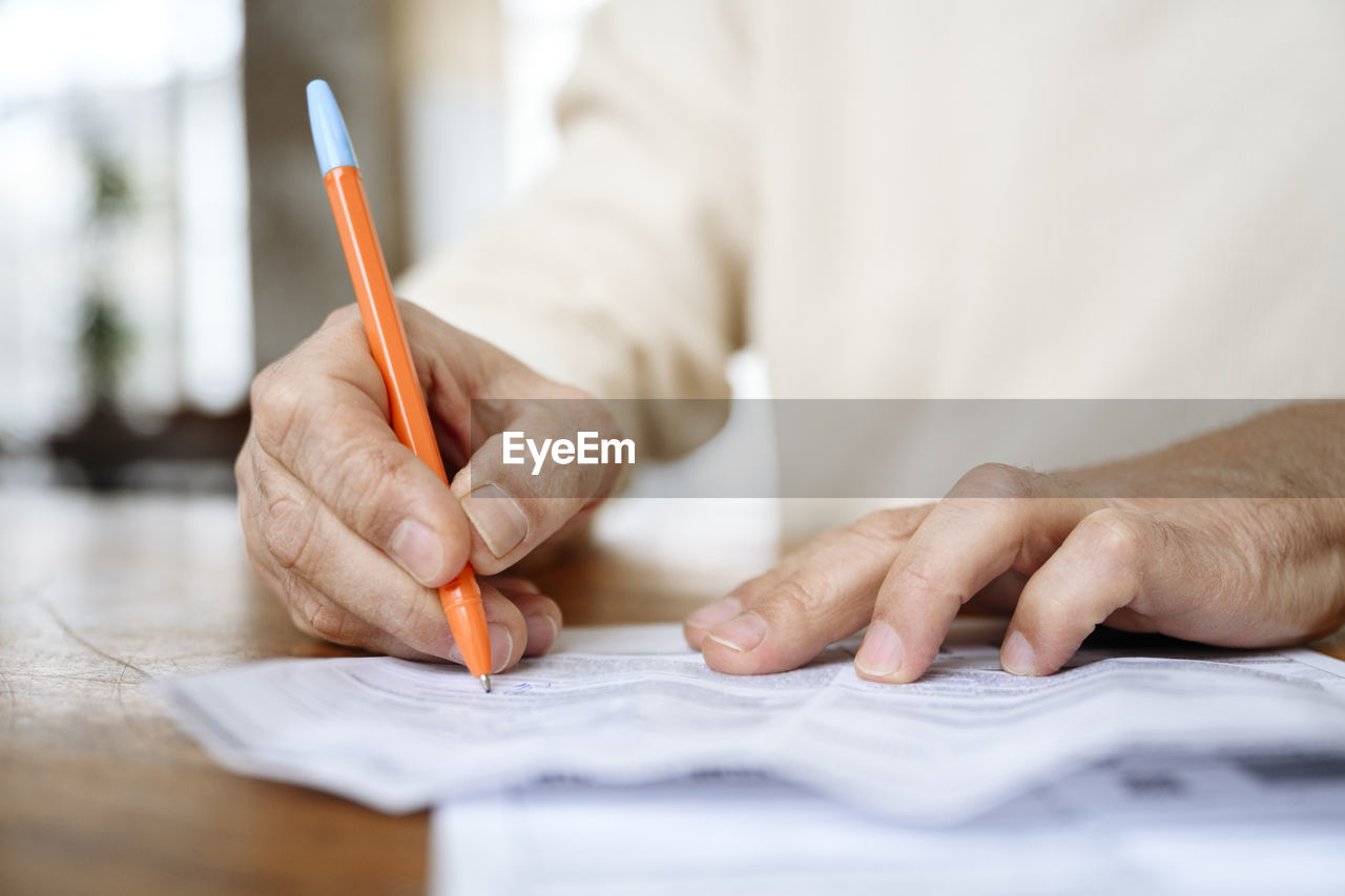 Man writing on bills with pen