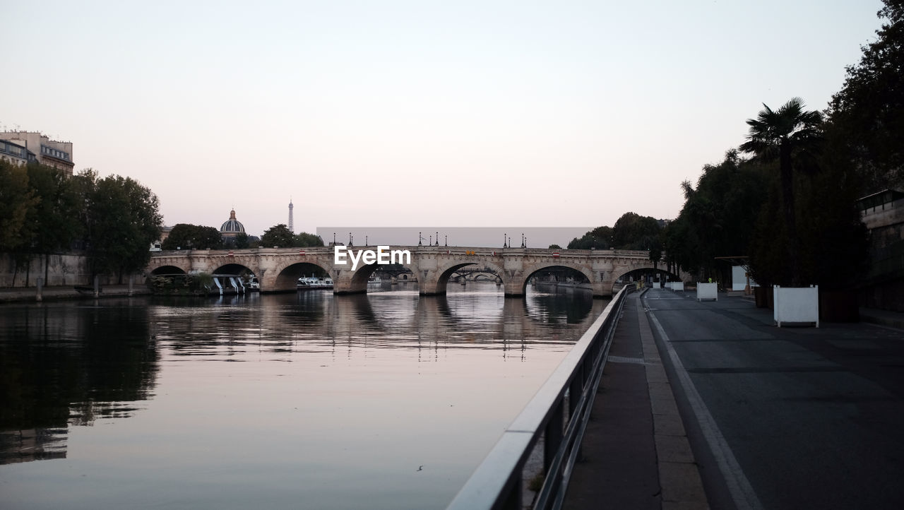 Bridge over river against clear sky during sunset