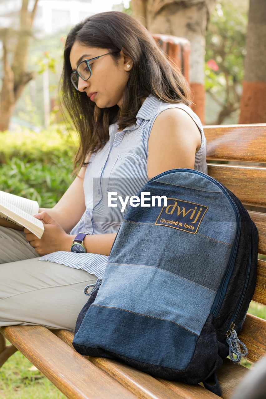 WOMAN SITTING ON BOOK