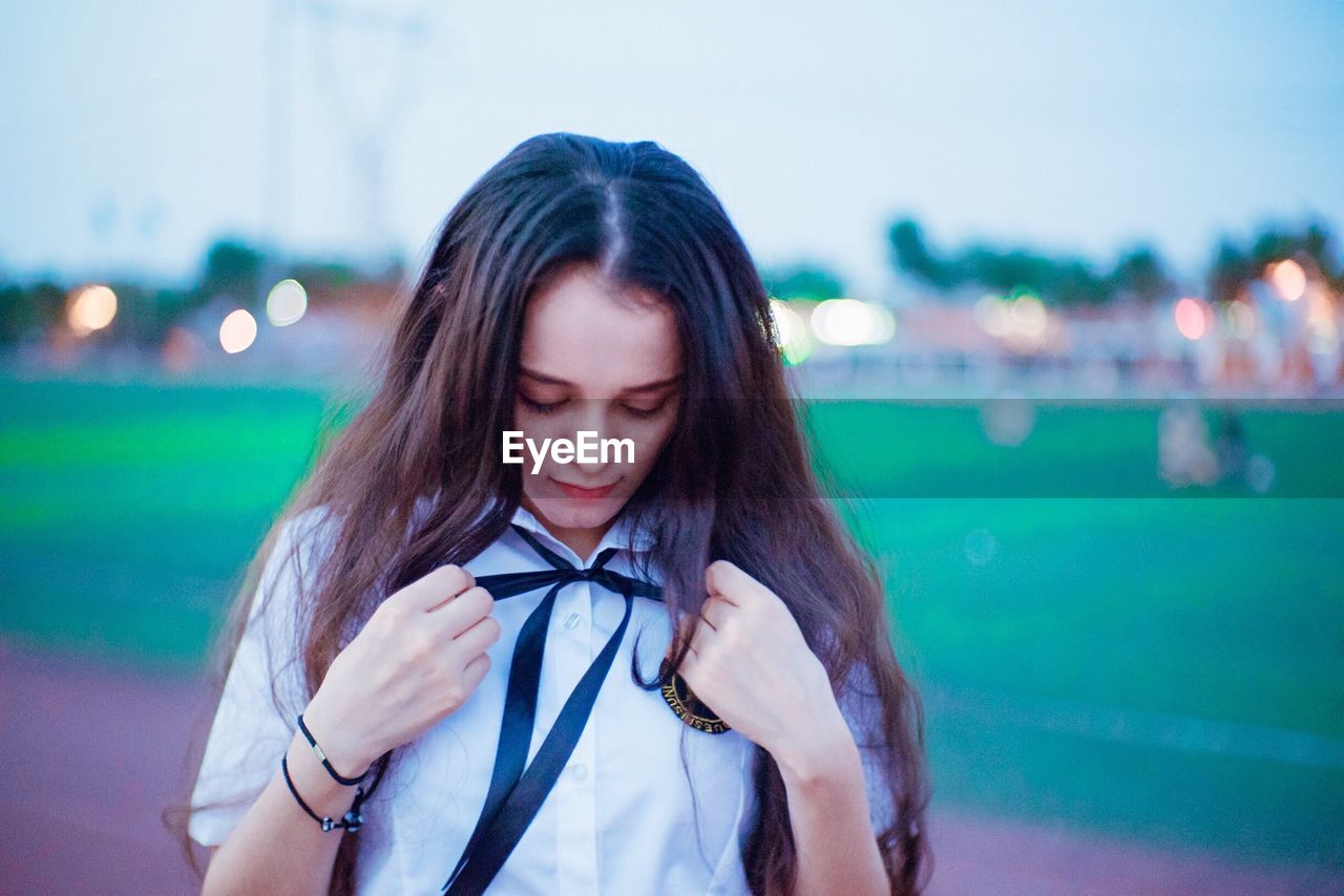 Close-up of young woman against sky
