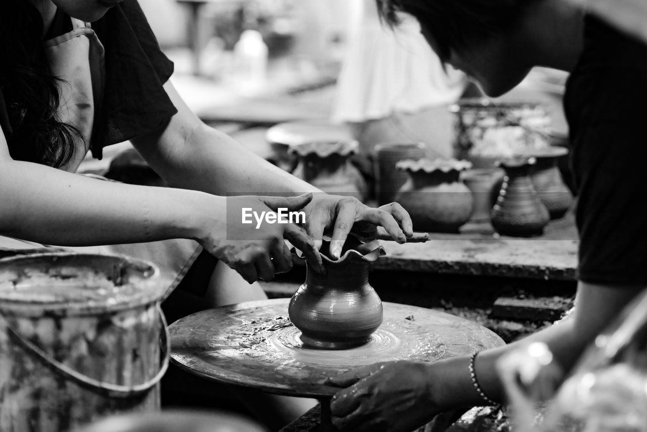 Midsection of women molding pot in workshop