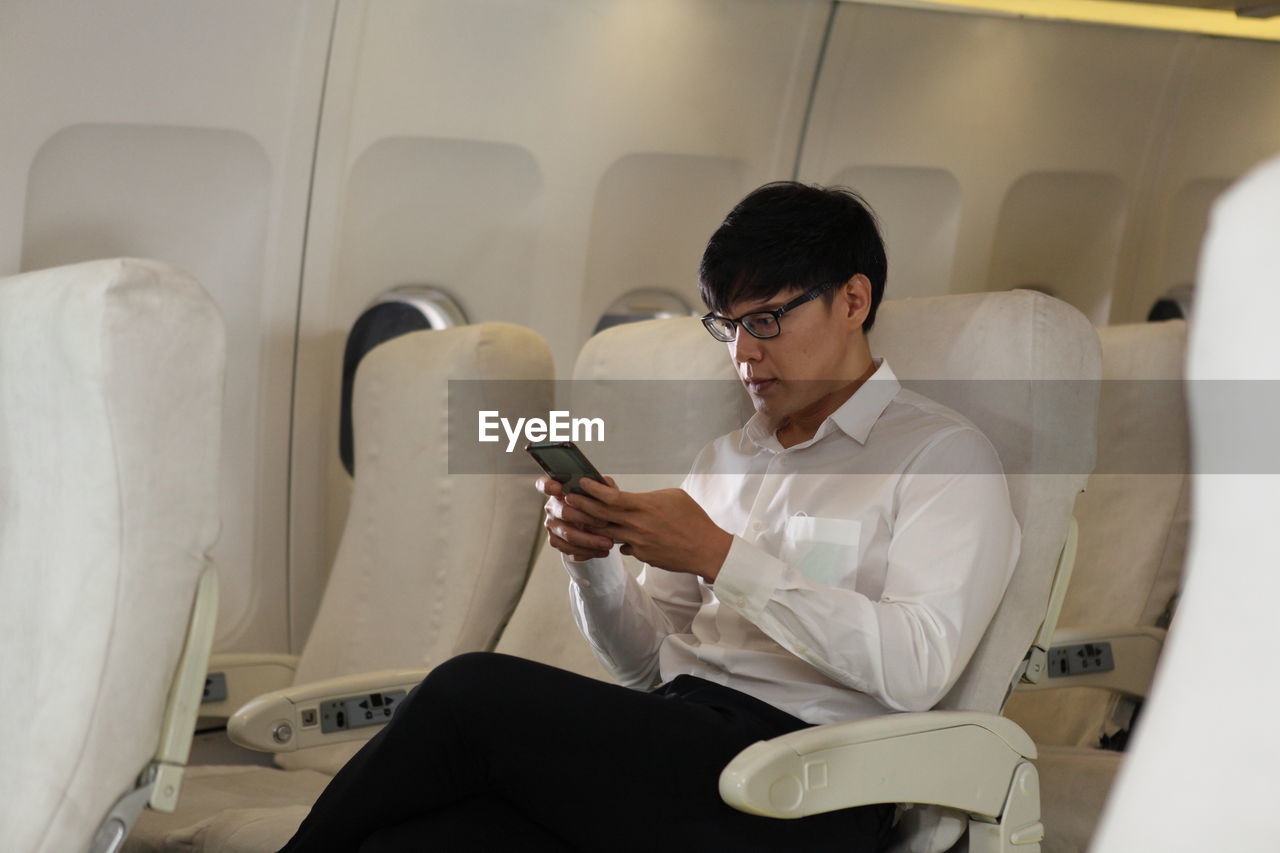 Young man using mobile phone while sitting in bus