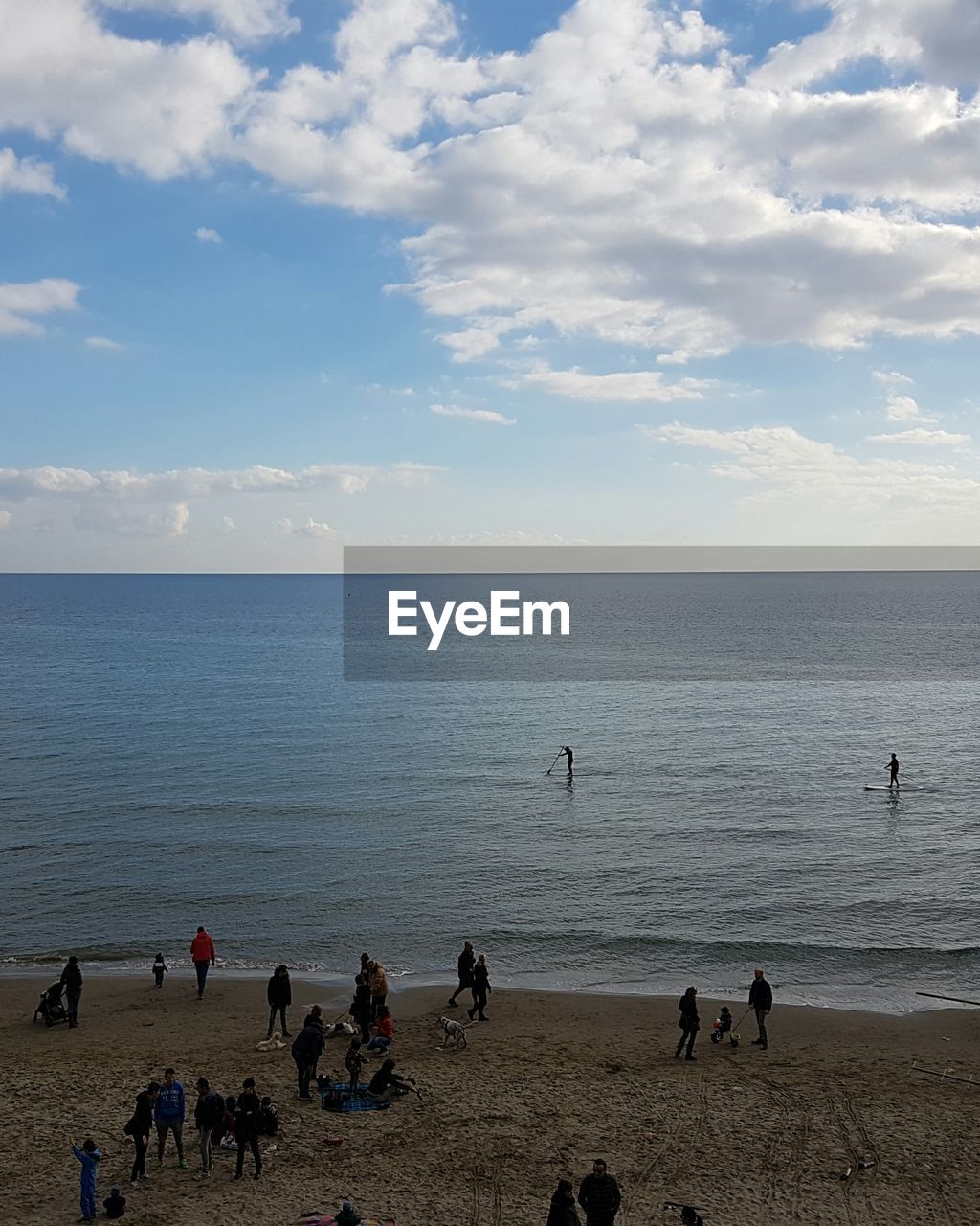 PANORAMIC VIEW OF PEOPLE ON BEACH AGAINST SKY