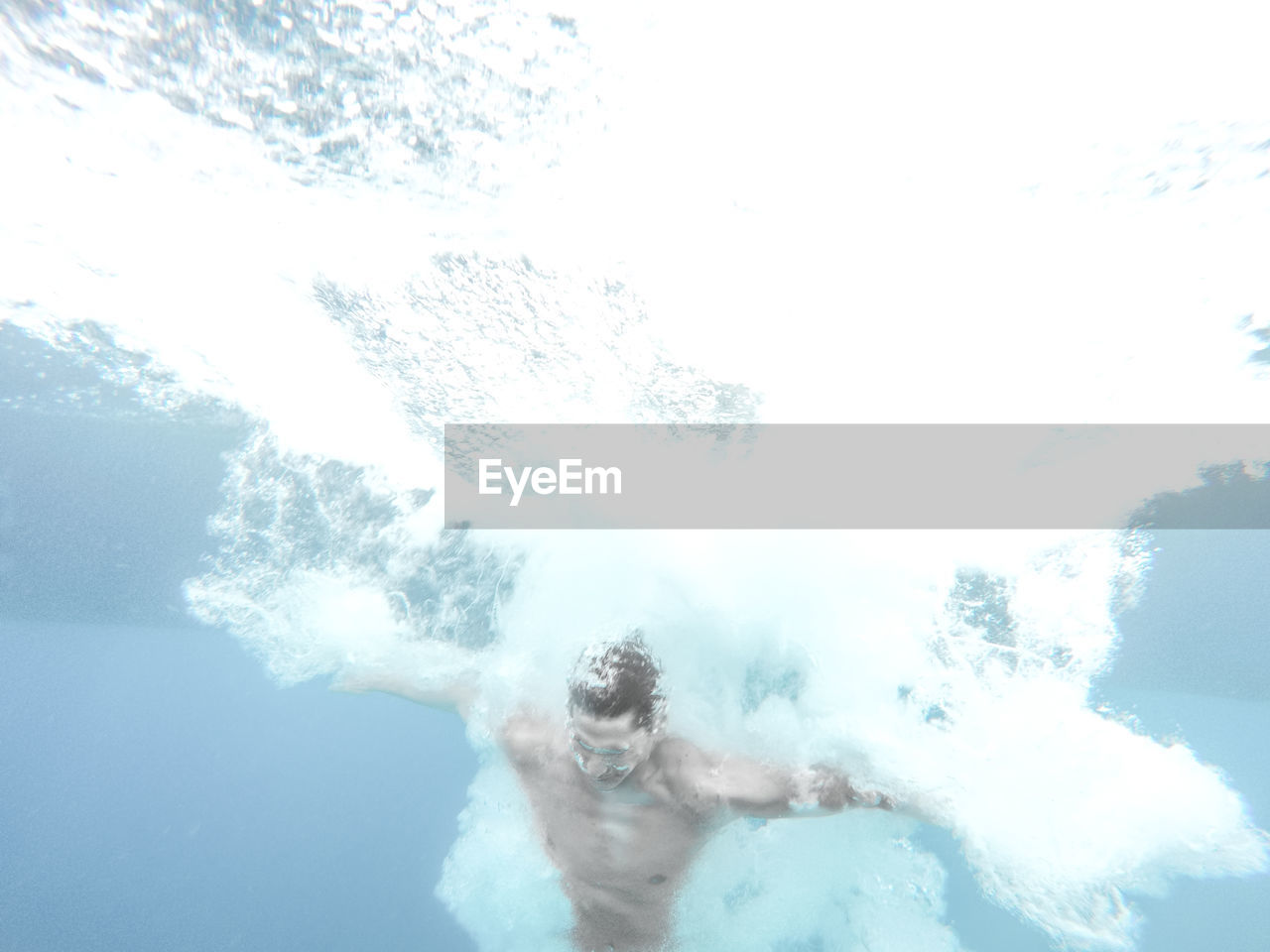 Low angle view of shirtless man swimming undersea