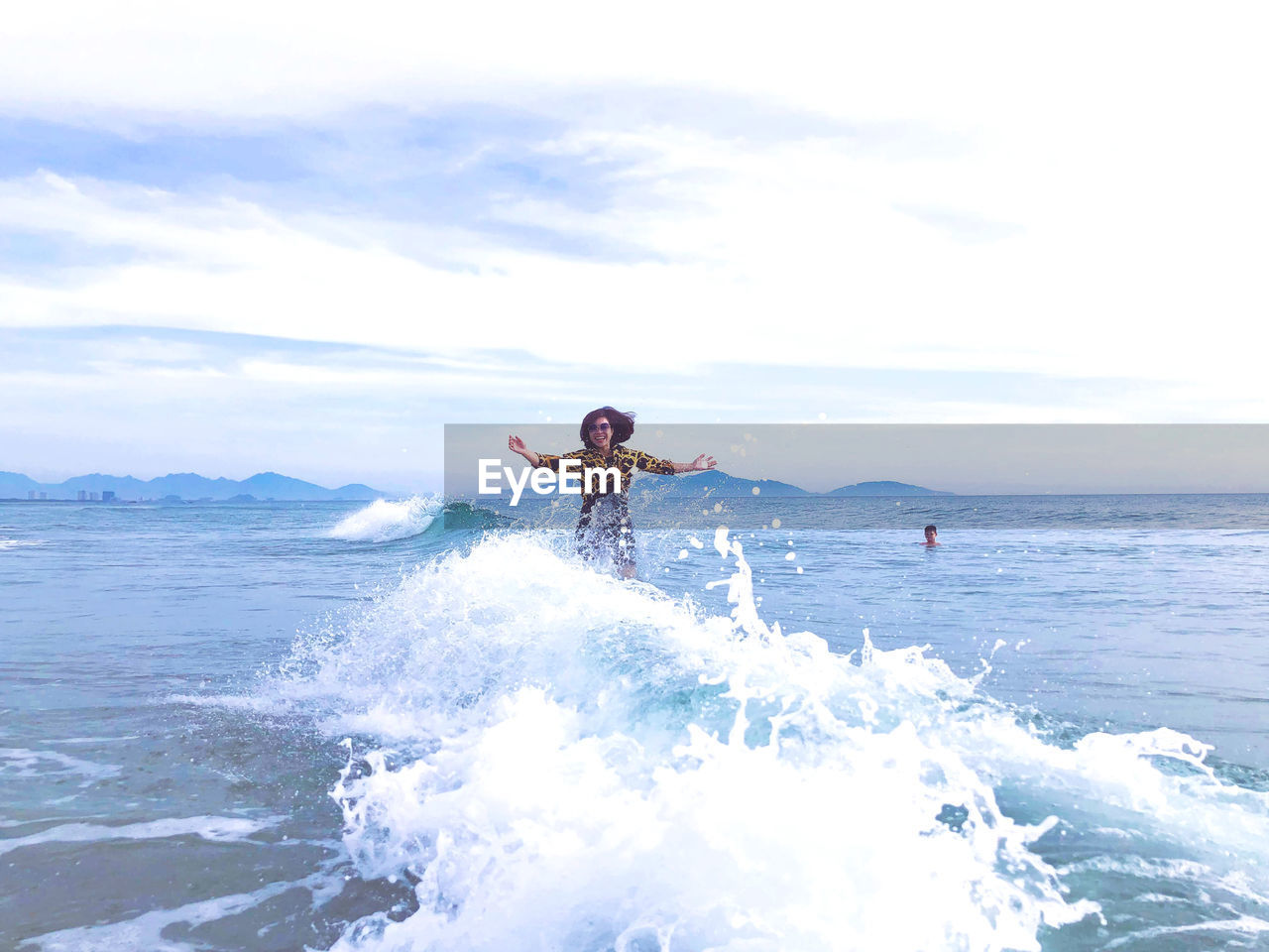 Woman surfing on sea against sky