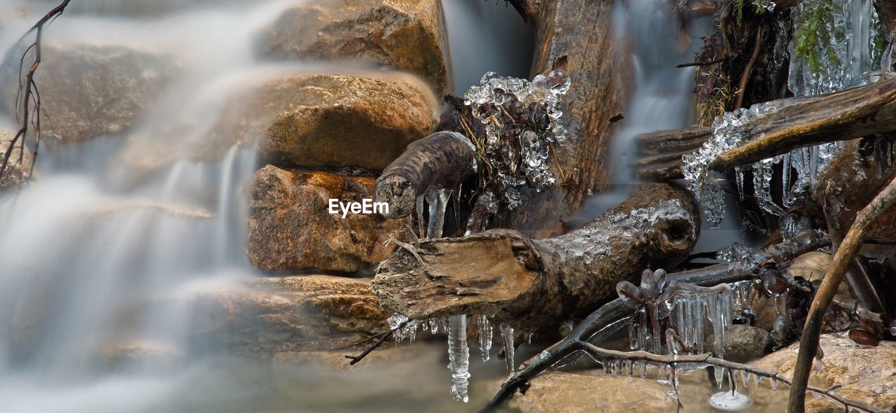 CLOSE-UP OF WATER FLOWING THROUGH WATERFALL