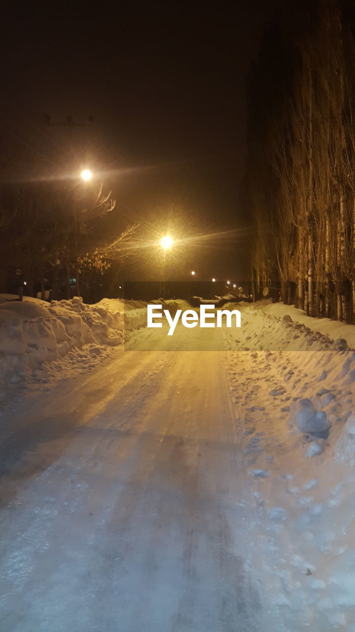 Illuminated street at night during winter