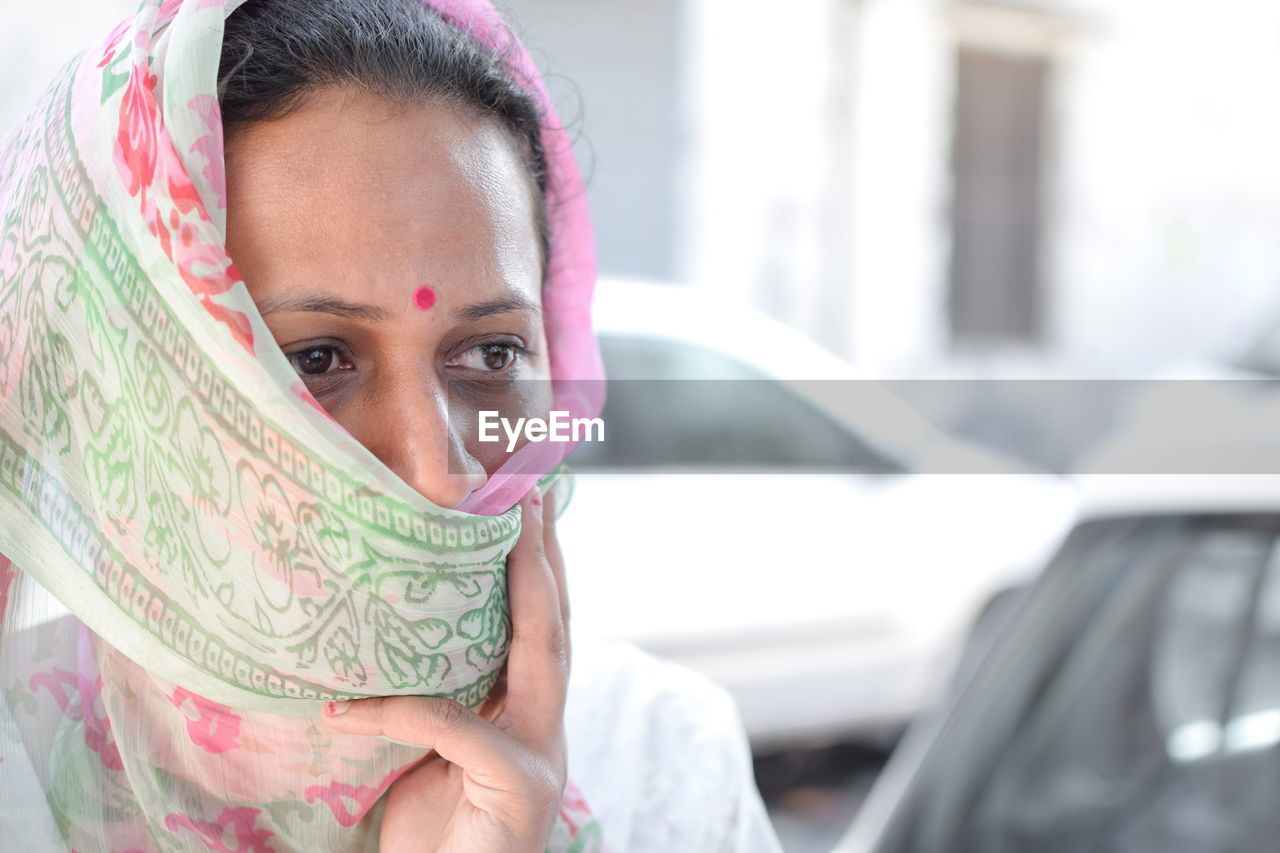 Close-up of thoughtful woman covering face with sari