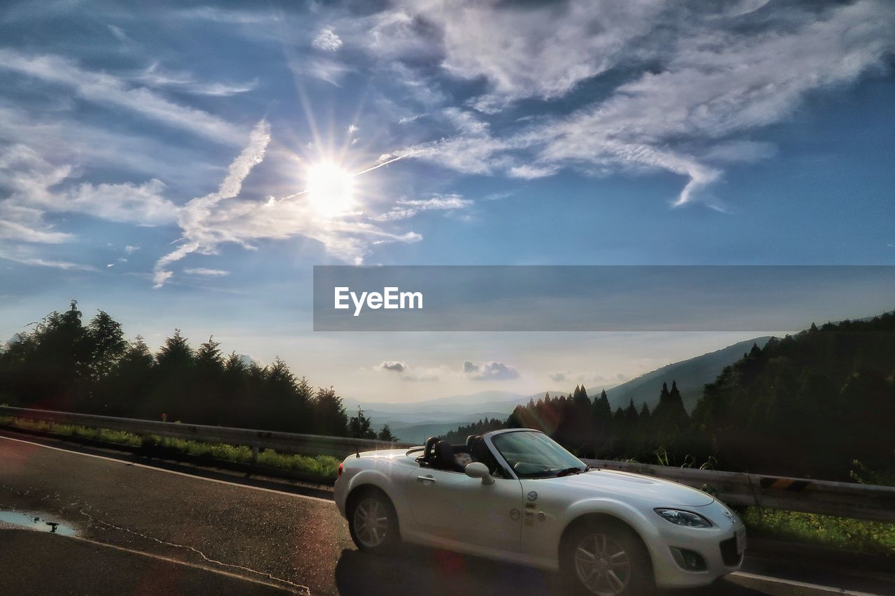 Car on road against sky at sunset