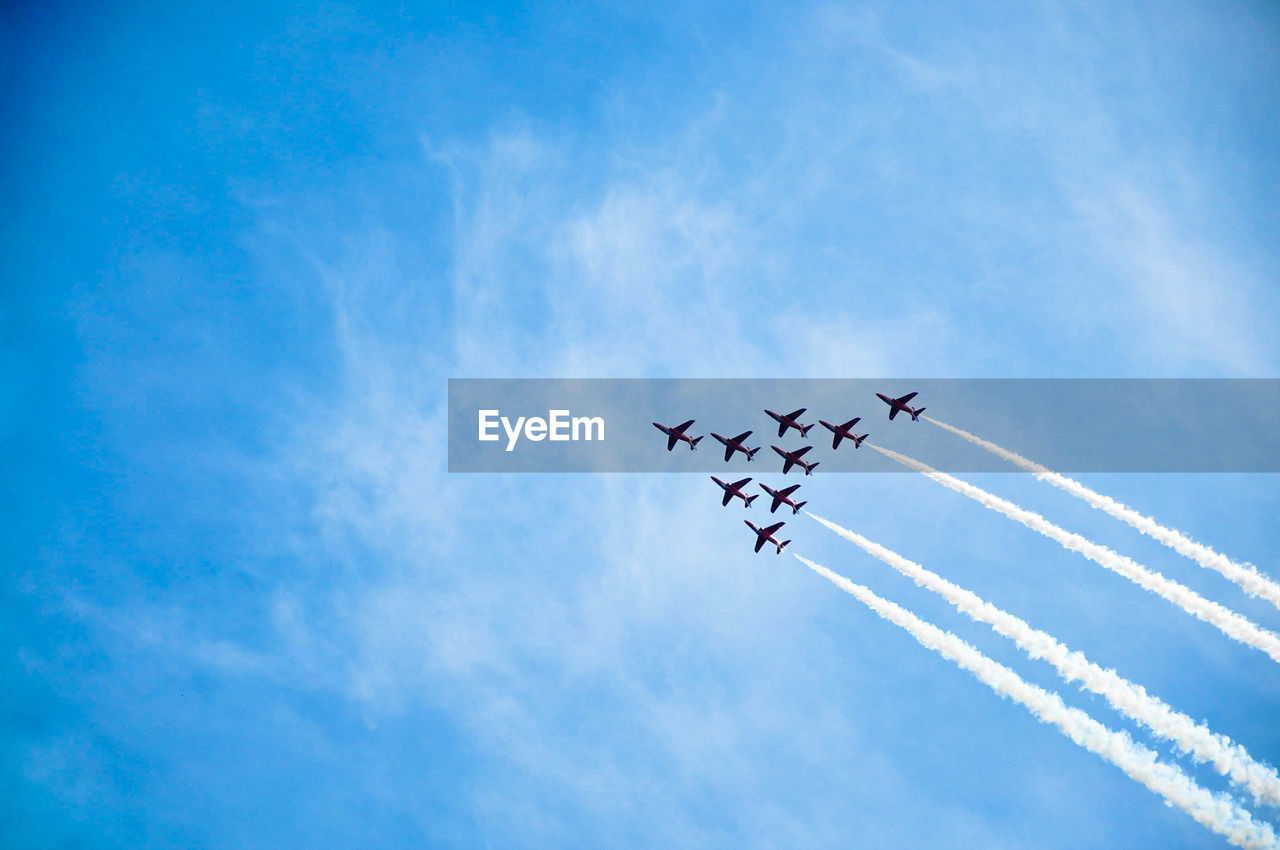 Low angle view of airplanes against blue sky