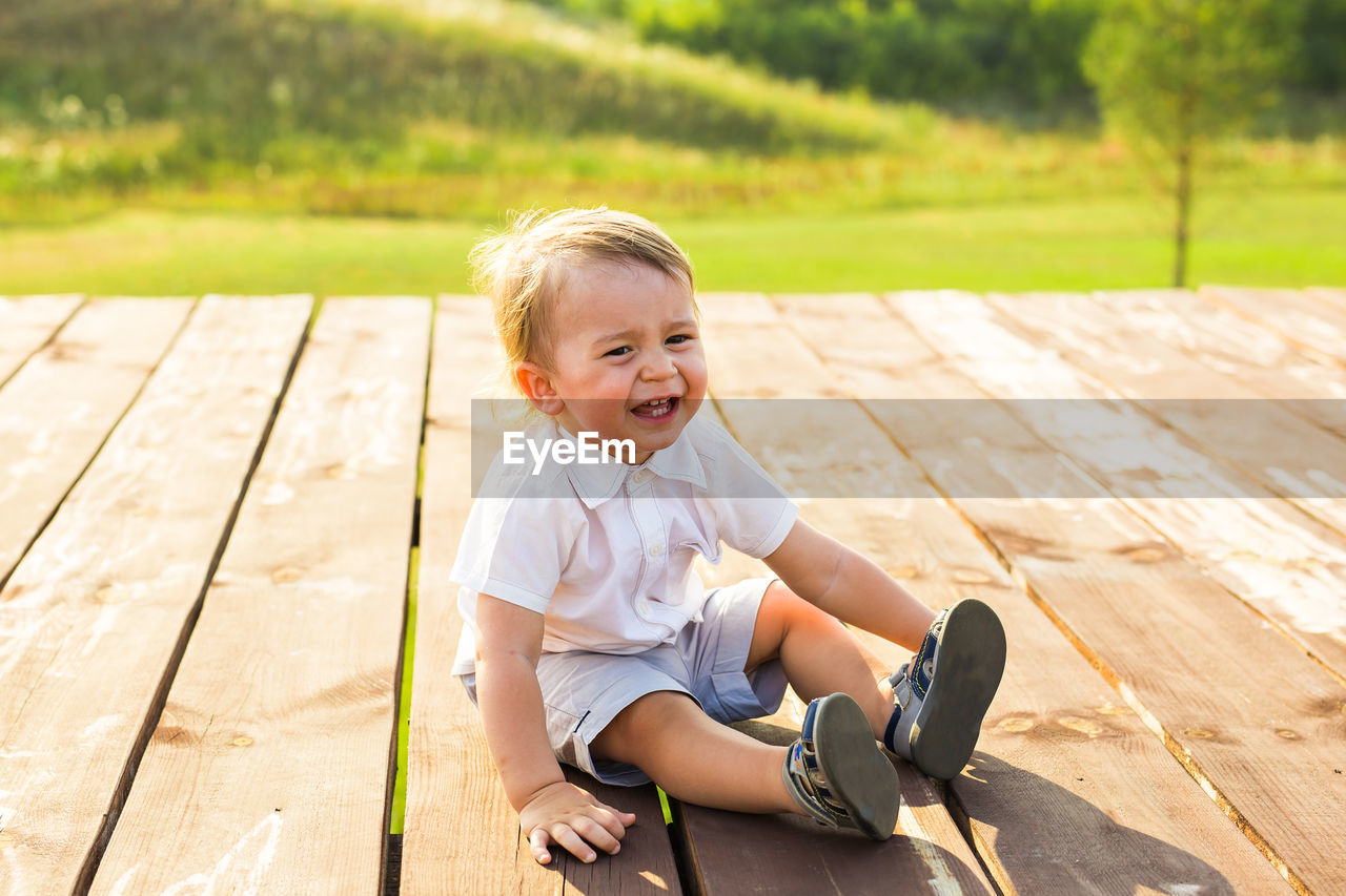 Crying boy sitting outdoors