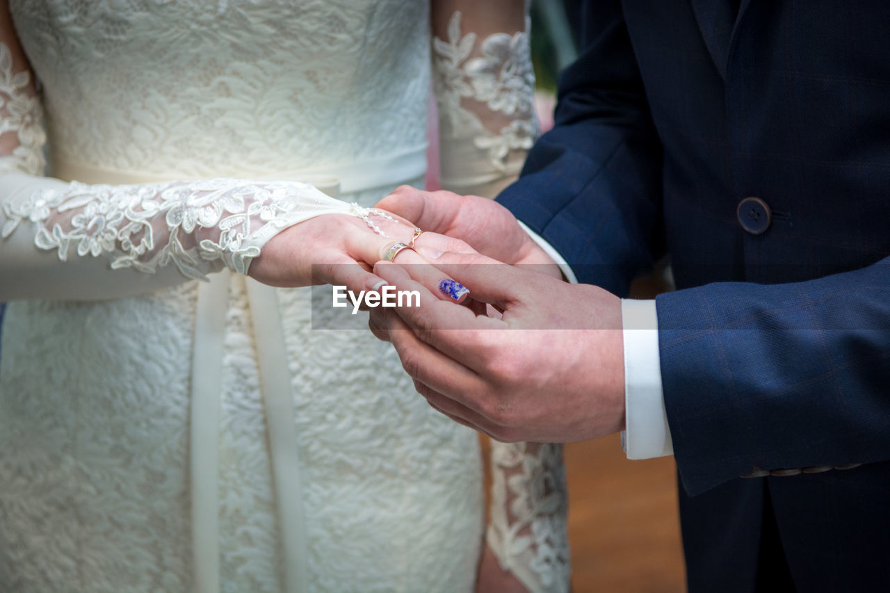 midsection of bride holding hands