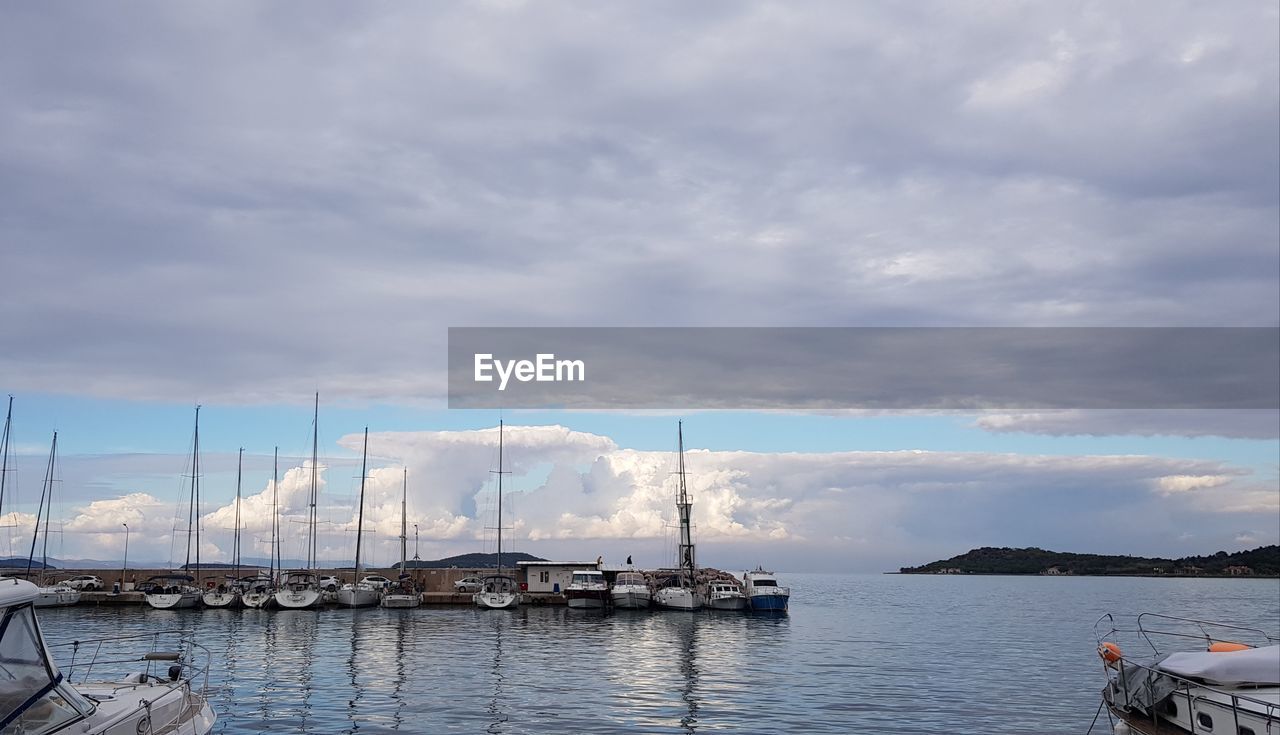 SAILBOATS MOORED IN HARBOR