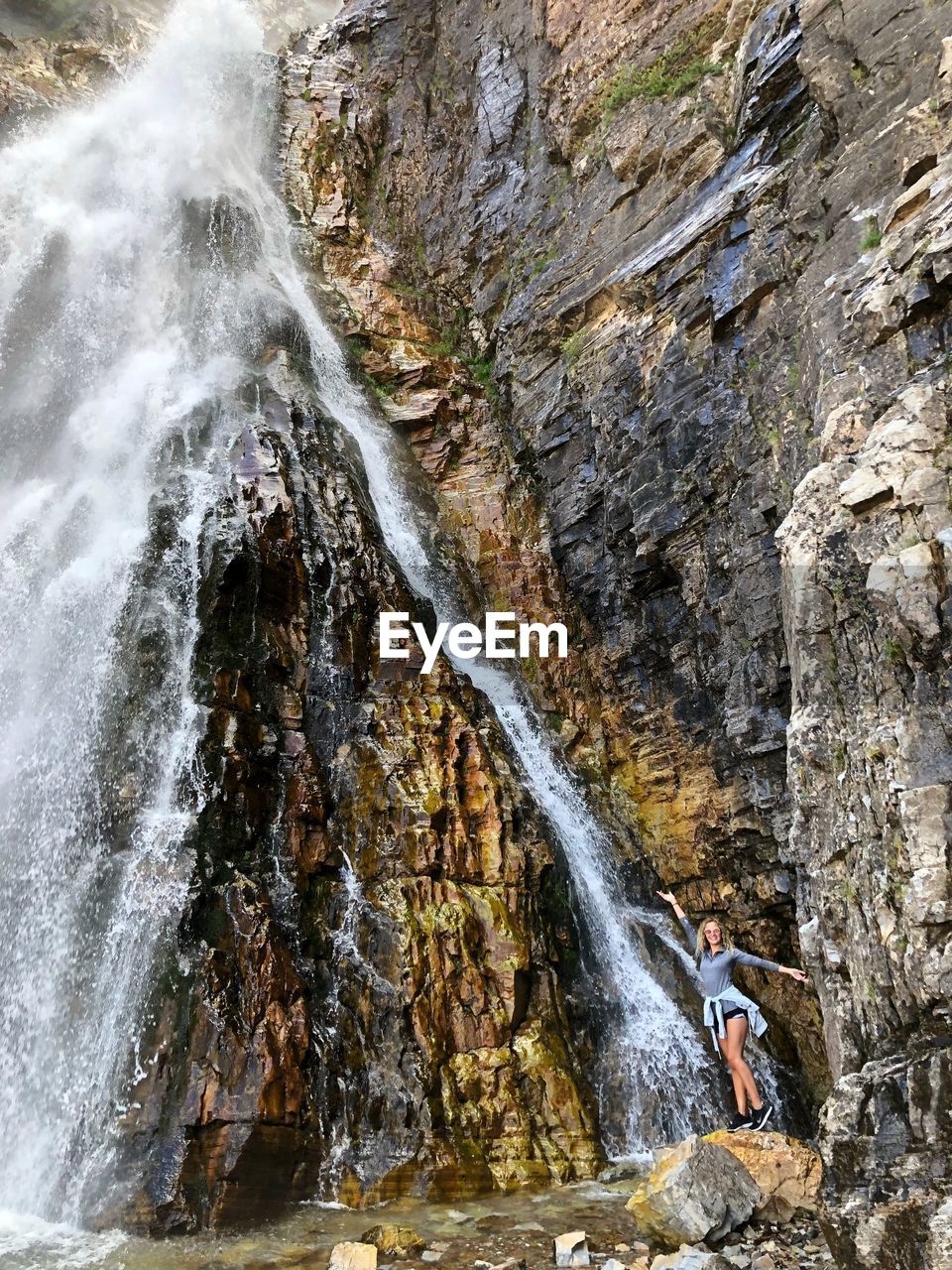 Full length off woman standing by waterfall