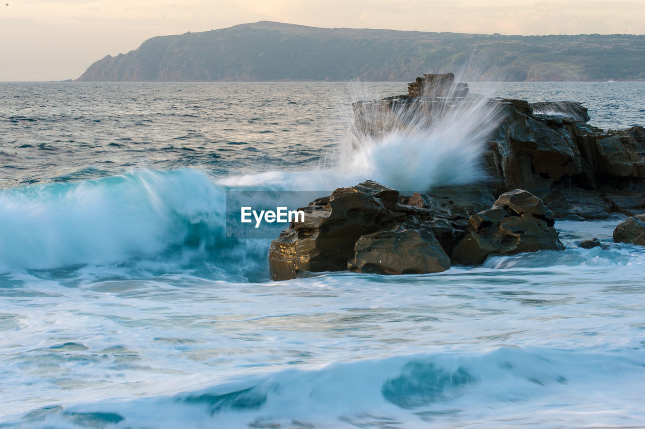 Waves splashing on rocks in sea