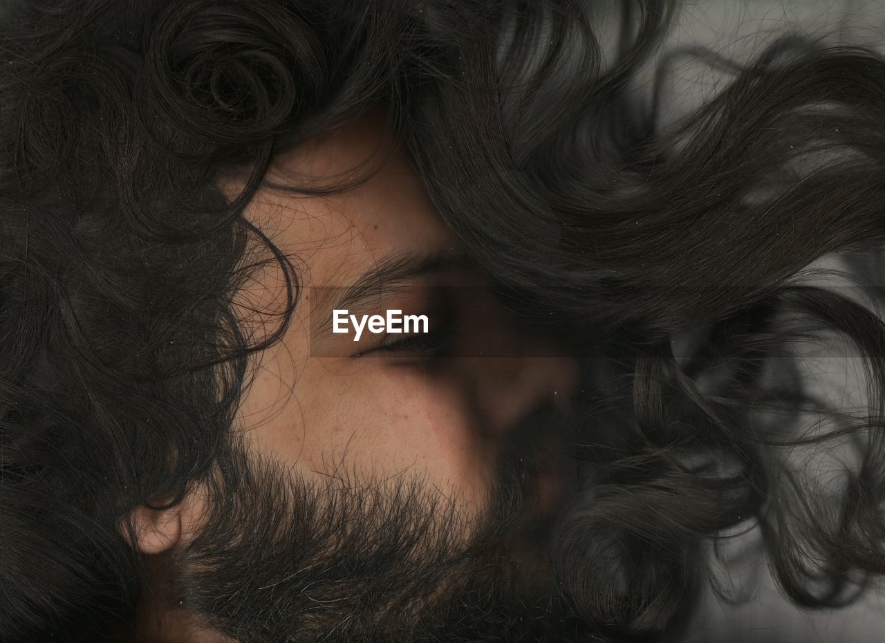 Close-up of young man amidst black hair