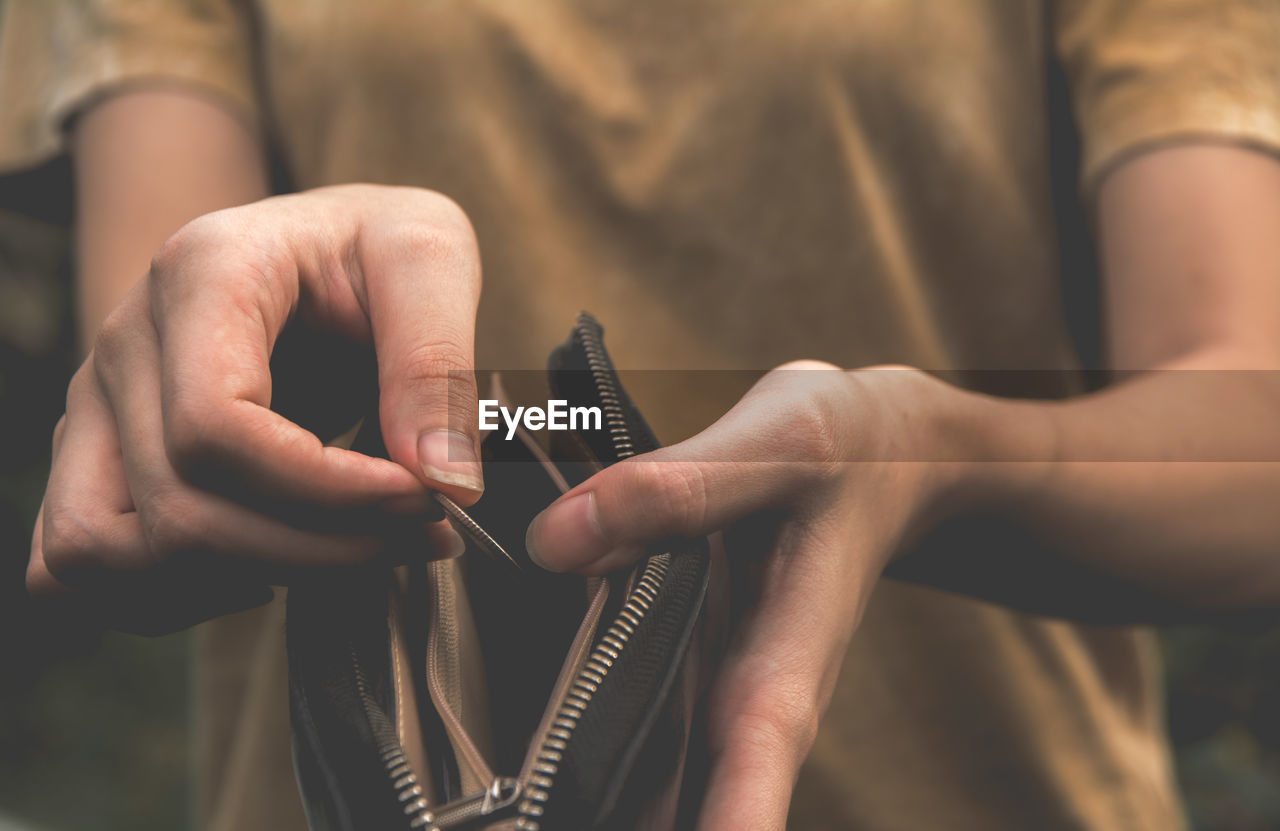 Midsection of woman holding purse and coin