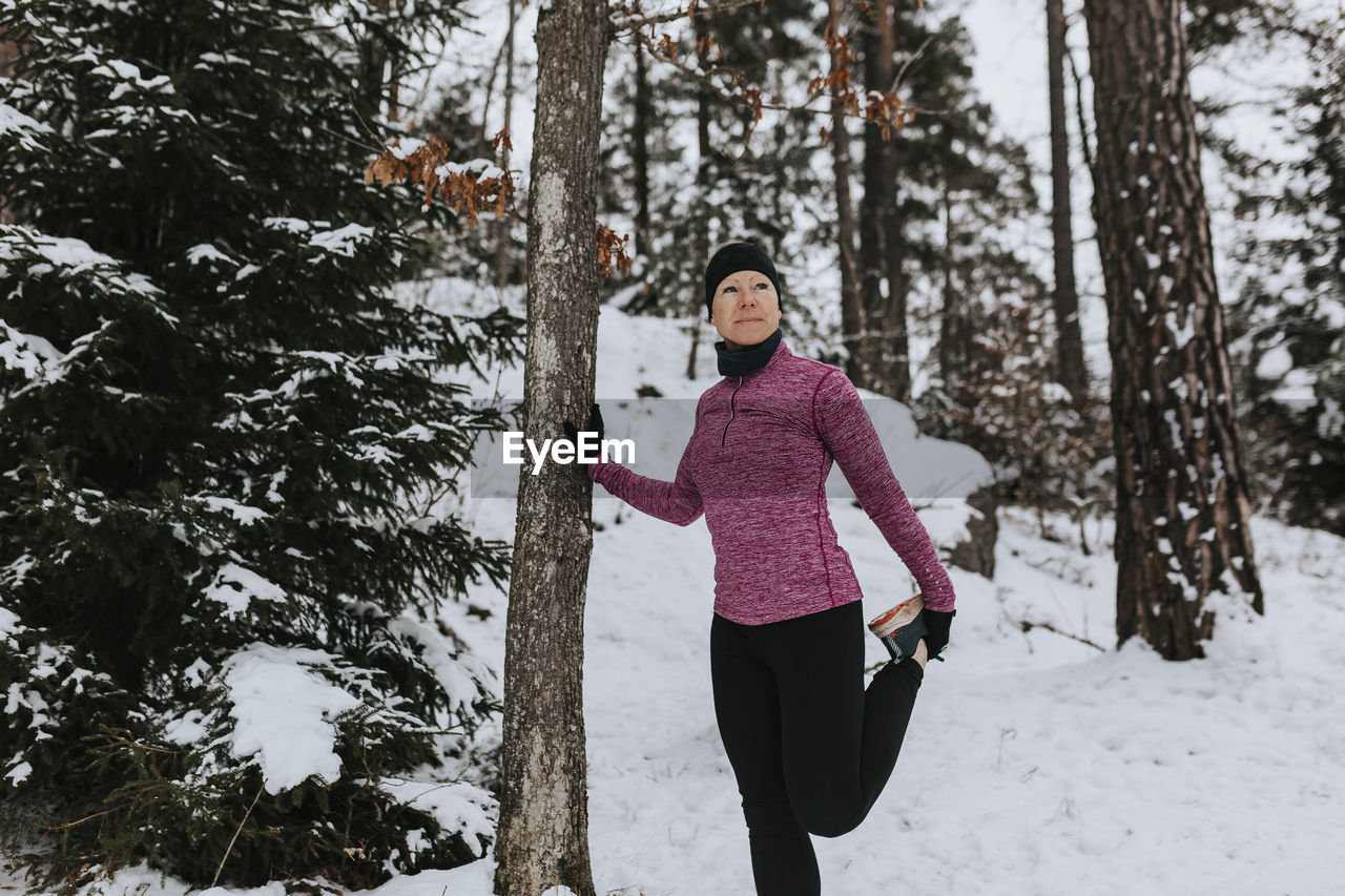 Woman stretching in winter forest