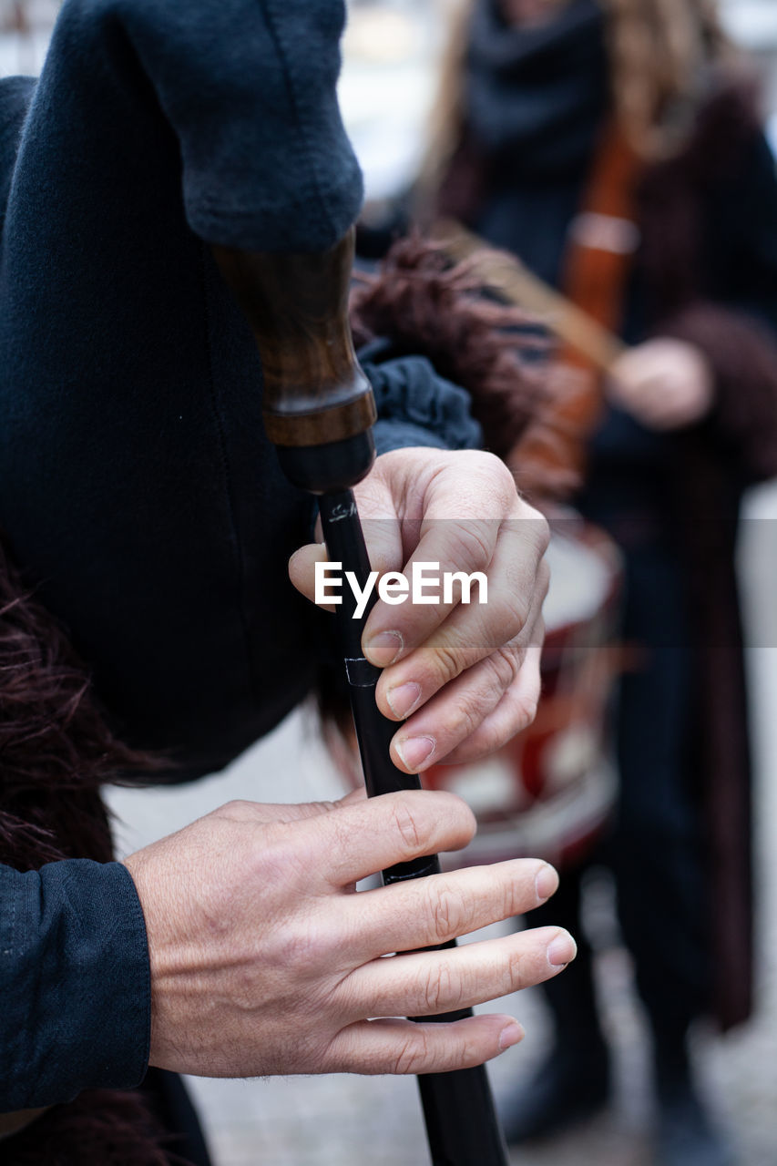 Close-up of human hands playing bagpipe in city