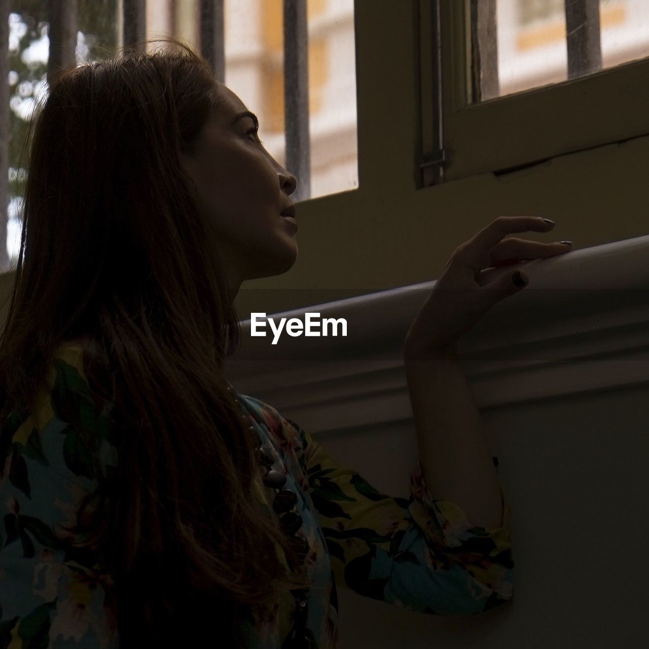 Low angle view of woman looking through window