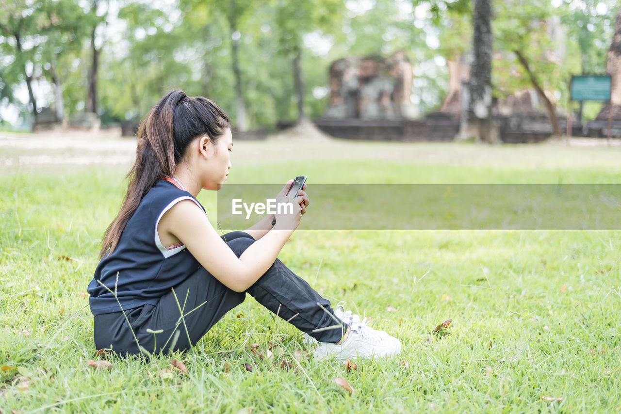 Gorgeous, modern and young woman, spending her leisure time on a spring day in the park.