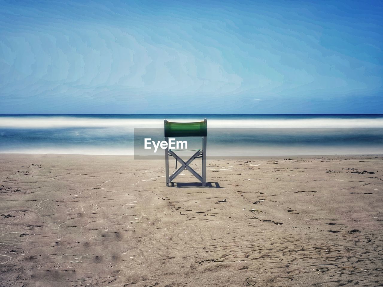 DECK CHAIRS ON BEACH AGAINST SKY