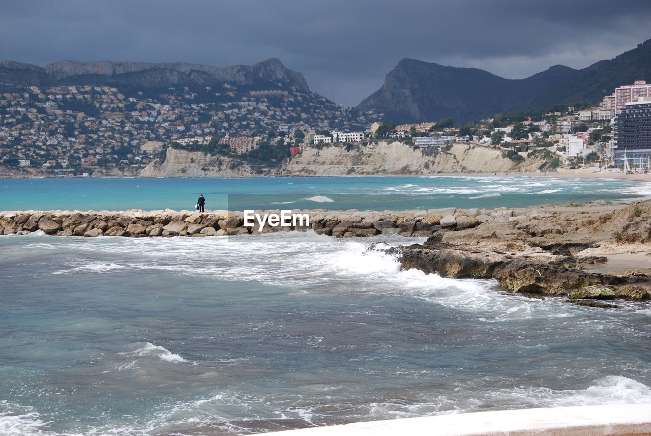 Person on groyne amidst sea