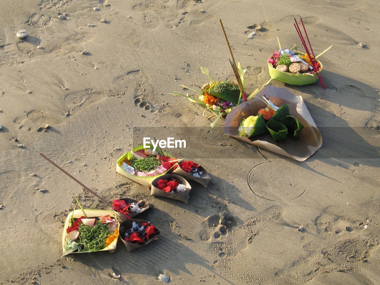 High angle view of buddhist offering on sand at beach