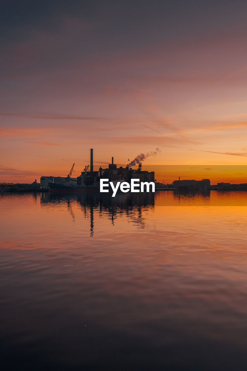 SHIP IN SEA AGAINST ORANGE SKY