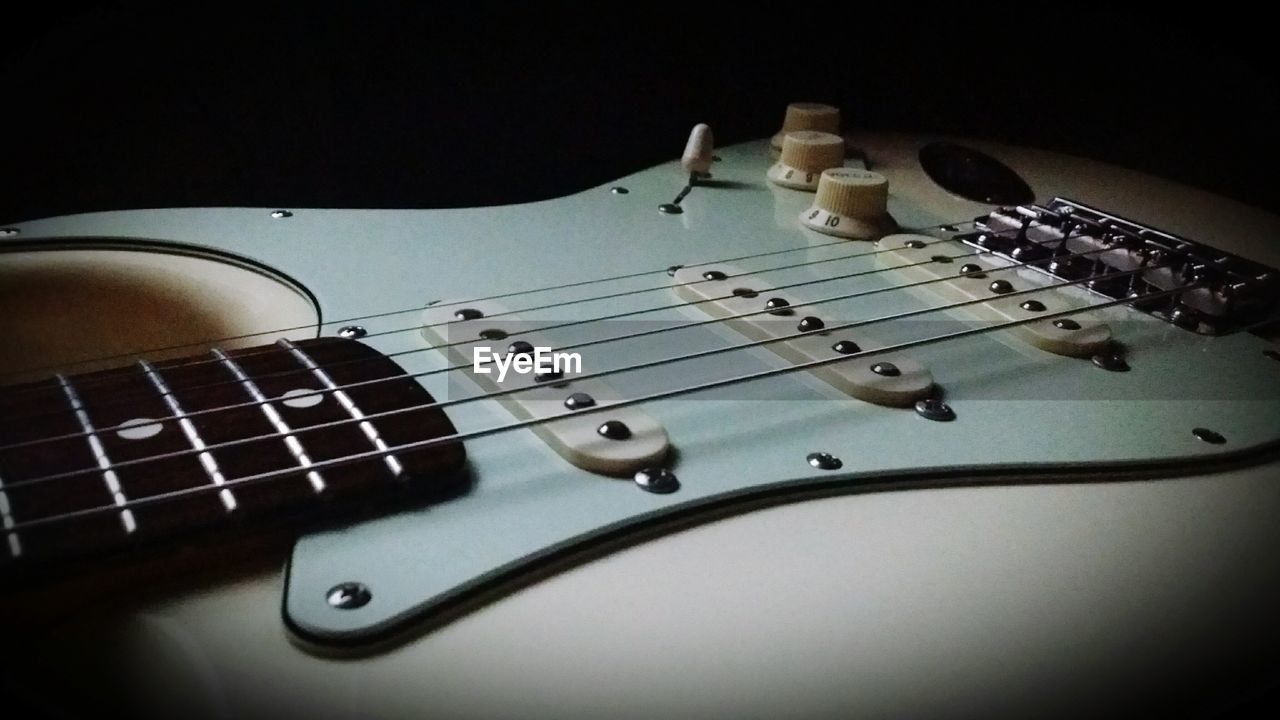 CLOSE-UP OF GUITAR ON PIANO