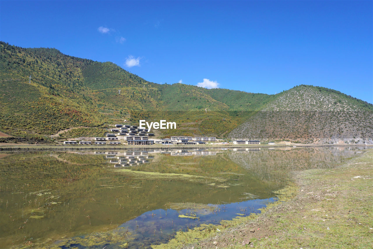 LAKE BY BUILDING AGAINST SKY