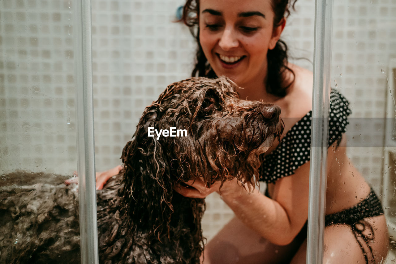 Smiling woman washing dog