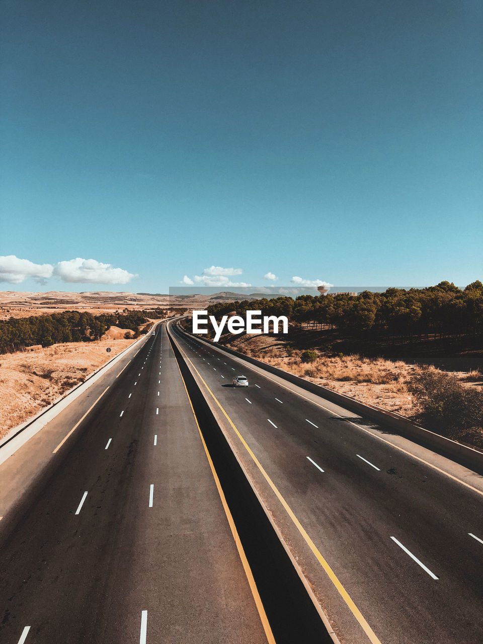 Road passing through landscape against blue sky