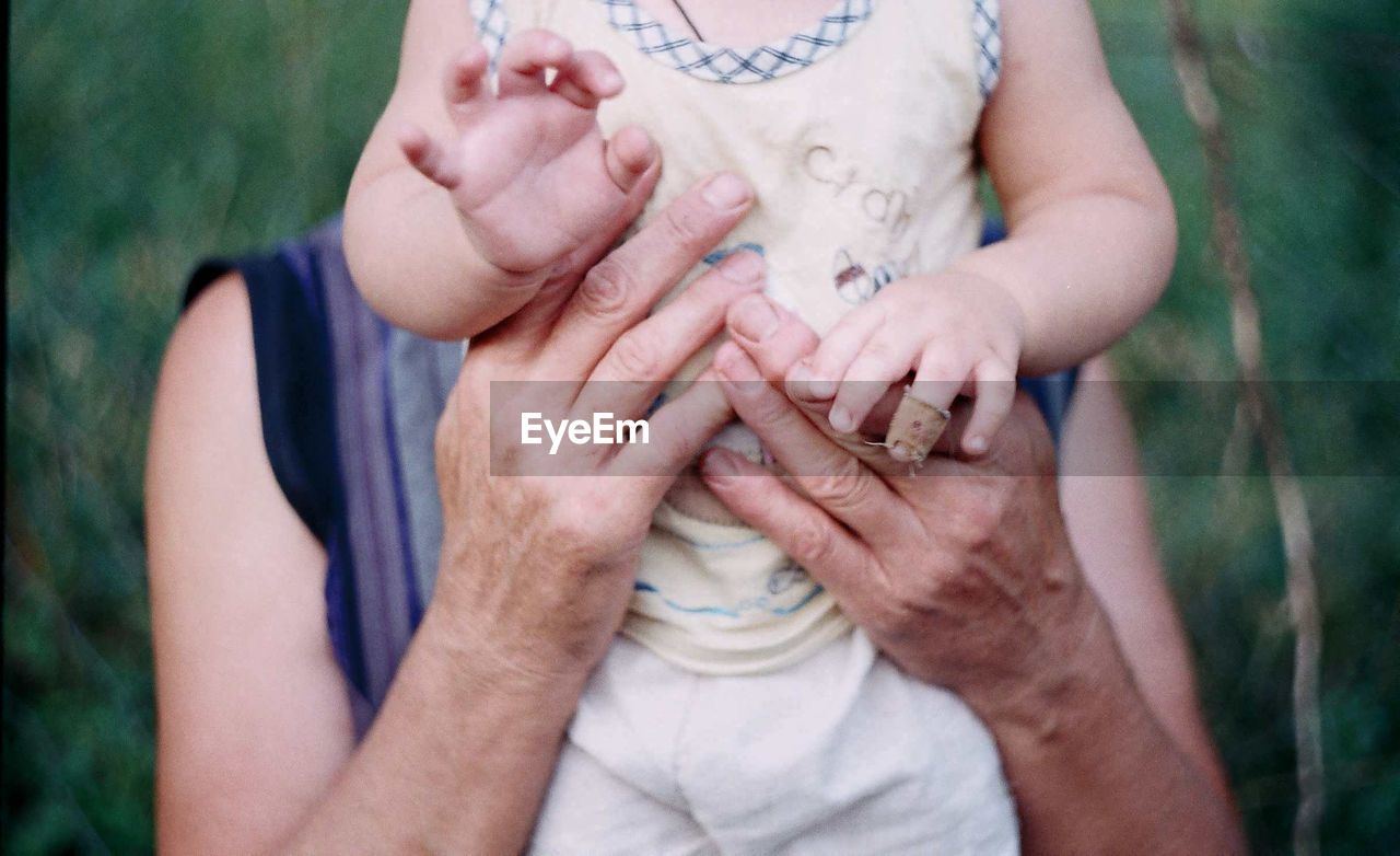 Midsection of woman holding baby