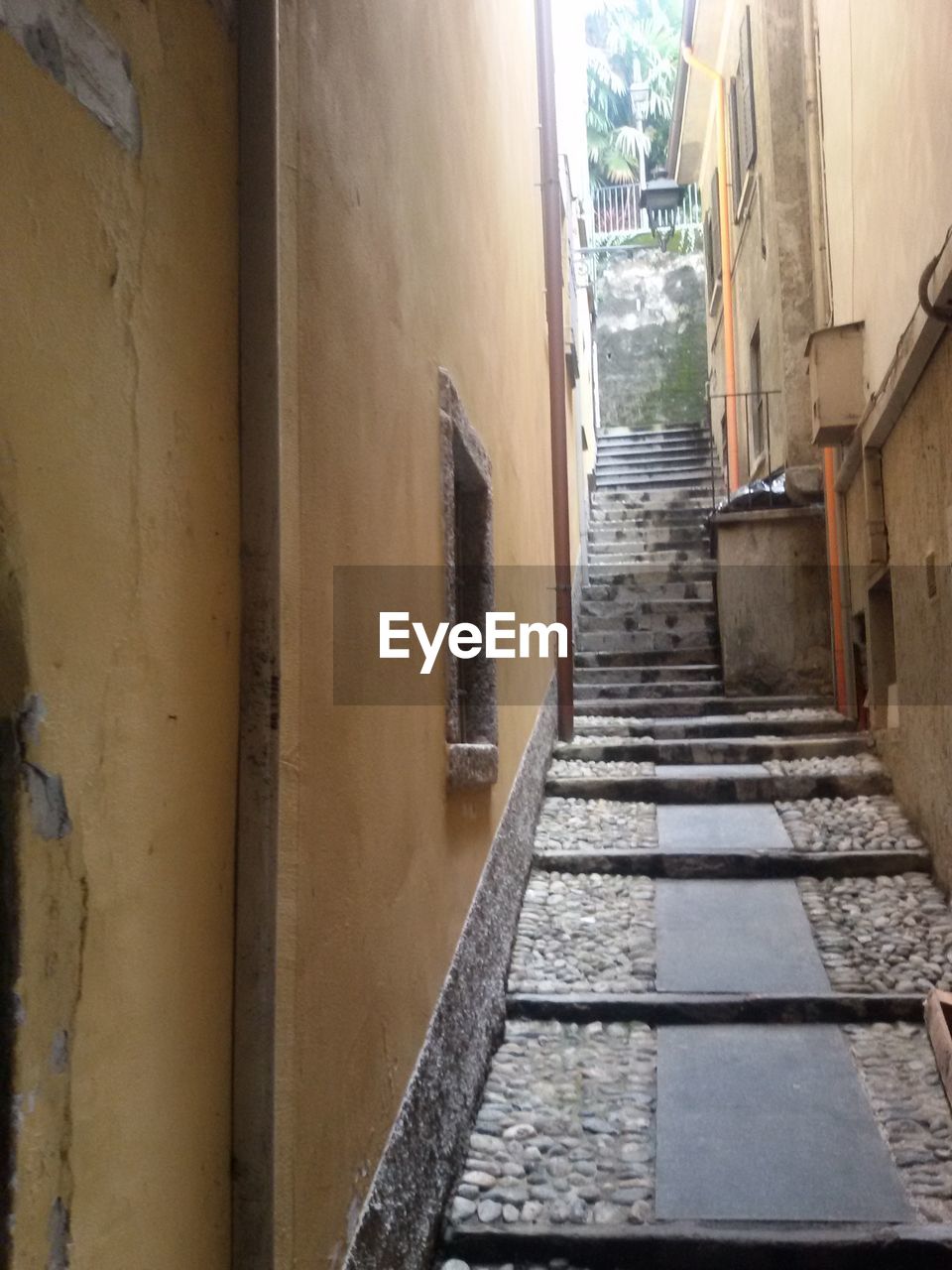 NARROW ALLEY WITH BUILDINGS IN BACKGROUND