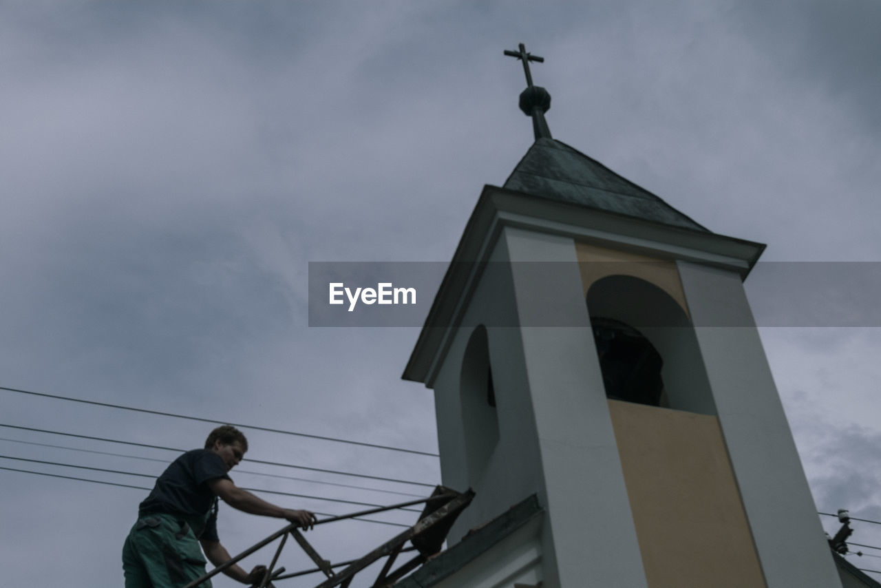 LOW ANGLE VIEW OF CROSS AGAINST TEMPLE