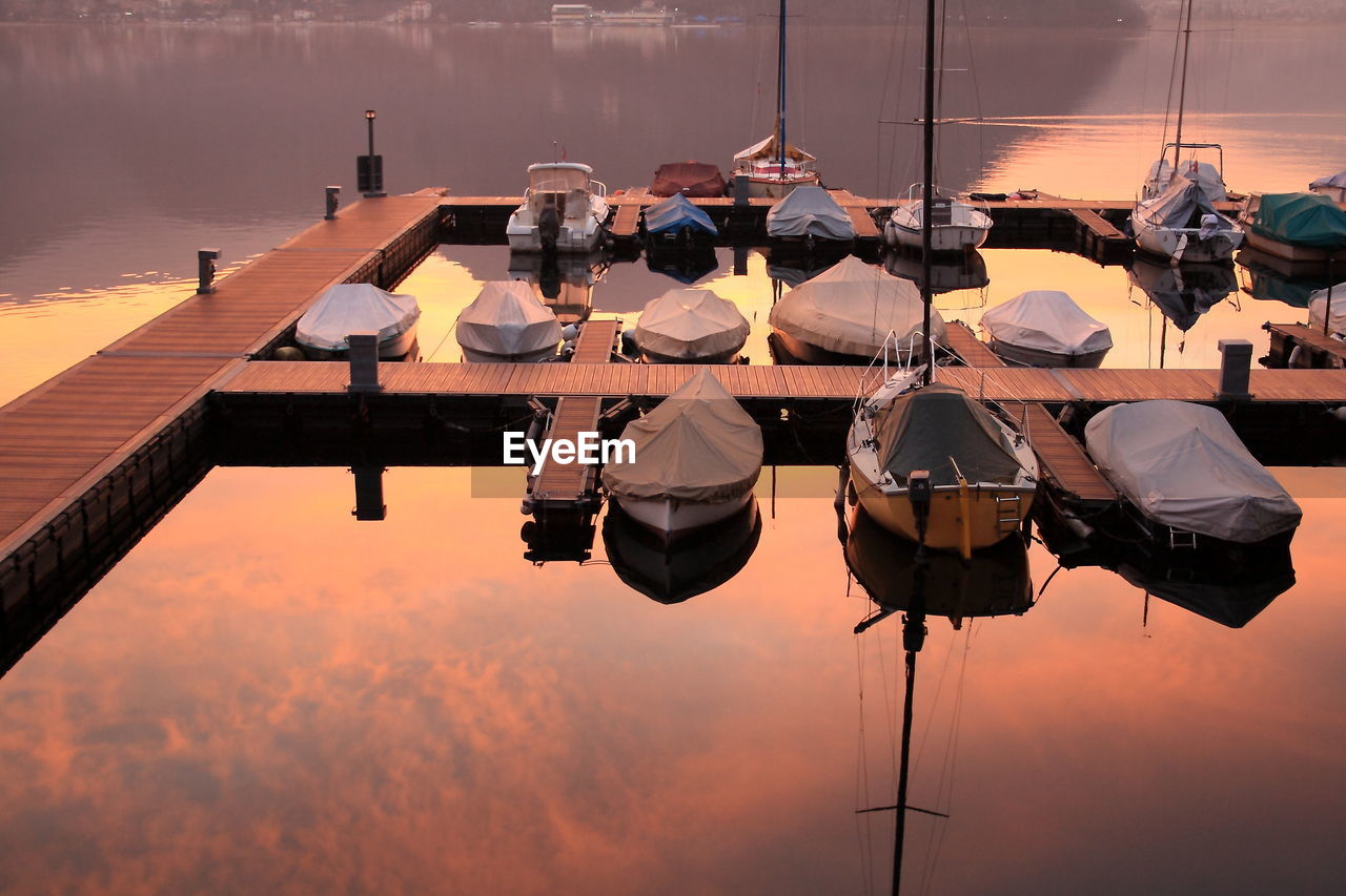 High angle view of boats moored at pier in lake during sunset