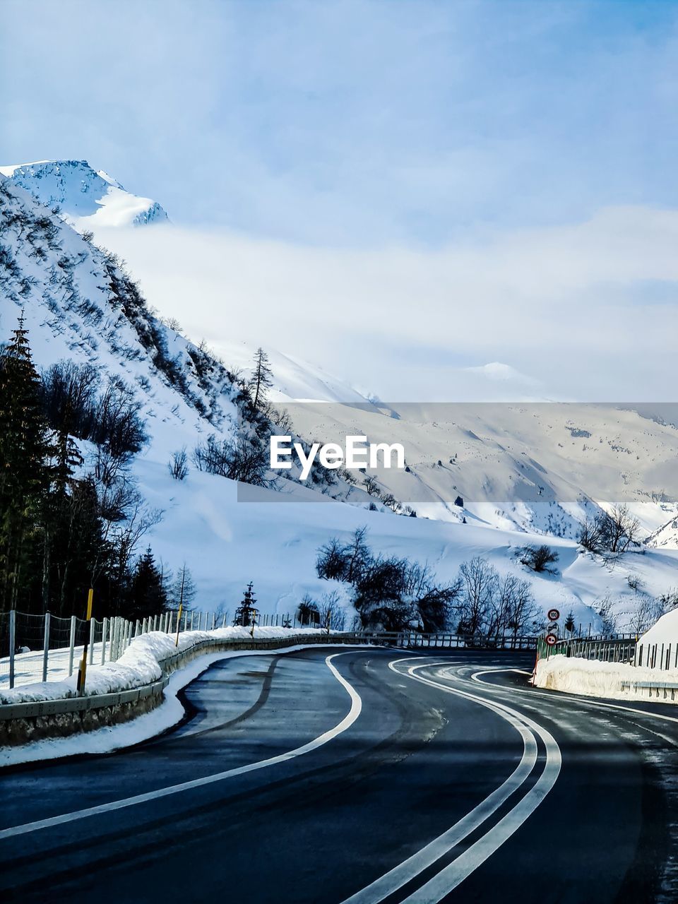 Scenic view of mountain road against snowcapped mountains