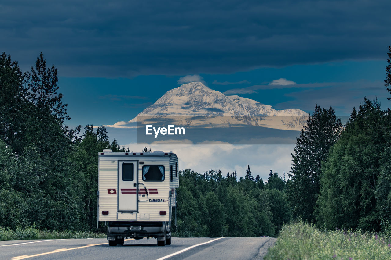 ROAD BY MOUNTAINS AGAINST SKY