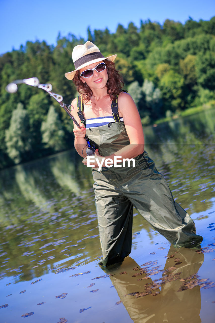 Portrait of woman fishing in lake 