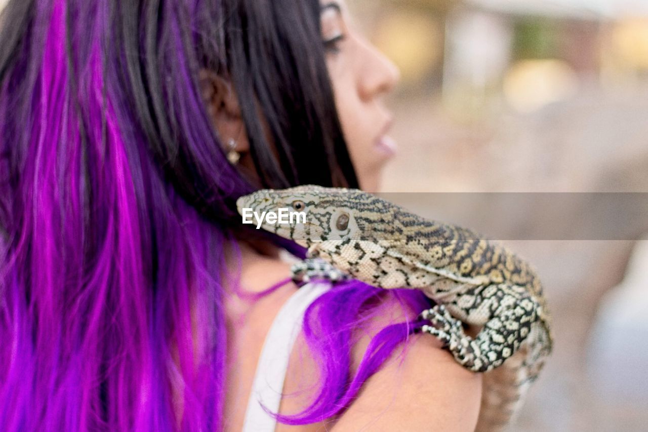 Close up monitor lizard on women's shoulder 