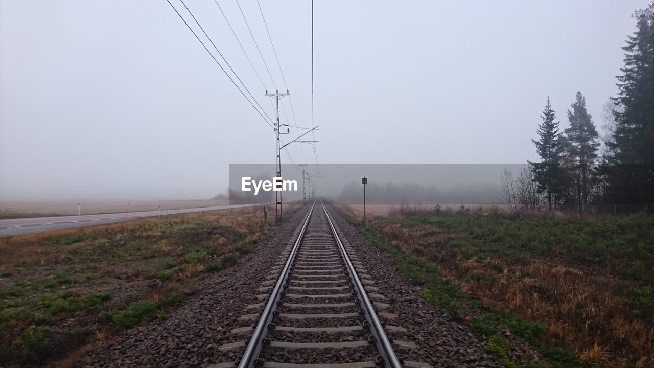 Railroad tracks against foggy weather