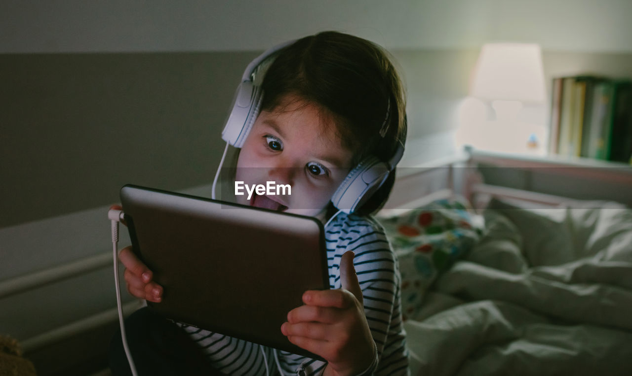 Girl listening music while using digital tablet at home