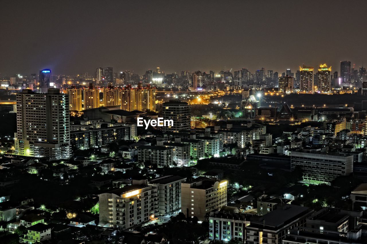 AERIAL VIEW OF ILLUMINATED CITYSCAPE AGAINST SKY